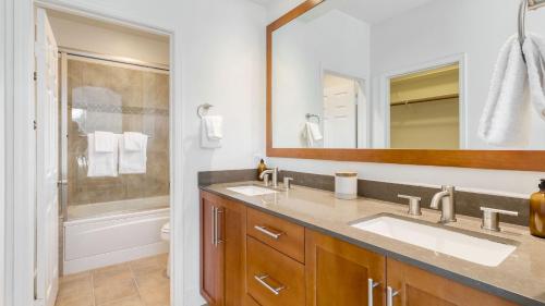 a bathroom with two sinks and a large mirror at Pool Hot Tub Yard Games Chic Midcentury Design Painted Sand by AvantStay in Bermuda Dunes