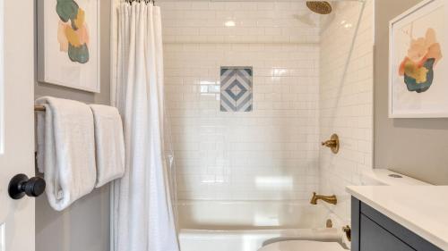 a white bathroom with a tub and a shower at North Bay by AvantStay Chic Retreat w Peloton in Blue Jay