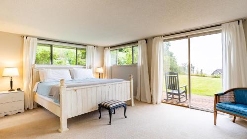 a bedroom with a bed and a large window at Private Beach Access Water Views Sleeps 18 Historic 6BDR Farmhouse w Deck in Clinton