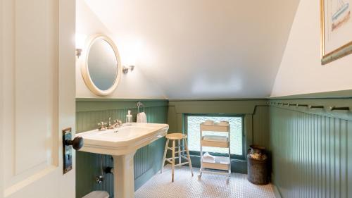 a bathroom with a sink and a mirror at Private Beach Access Water Views Sleeps 18 Historic 6BDR Farmhouse w Deck in Clinton