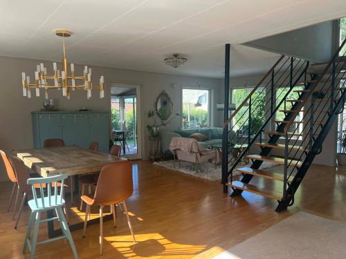 The Scandic Luxe - Landvetter Airport في Torslanda: غرفة طعام وغرفة معيشة مع طاولة ودرج