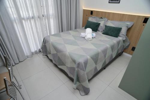 a teddy bear sitting on a bed in a bedroom at Green One - Em Frente à Estação Luz com vaga rotativa in Sao Paulo