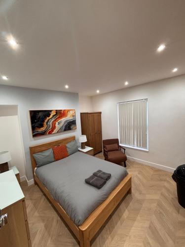 a bedroom with a bed and a chair in it at Hendham Rooms - Near Etihad Stadium, CoOp Live Arena, National Cycling Centre & 24 Hour Asda in Manchester