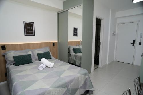 a bedroom with a bed with two towels on it at Green One - Em Frente à Estação Luz com varanda e vaga rotativa in São Paulo