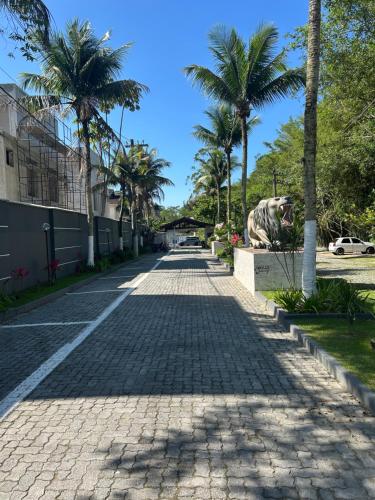 a cobblestone street with palm trees and a statue at Casa Condomínio Juquehy 100 M do Centrinho in Juquei