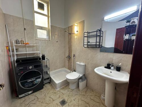 a bathroom with a toilet and a sink at Stylish 2 Bedroom with 2 outside area in Abu Dhabi