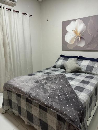 een slaapkamer met een bed met een zwart-witte deken bij Brisa das dunas in Tutóia