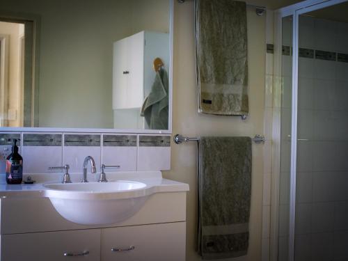 a bathroom with a white sink and a shower at Birdsland Suite in Belgrave Heights