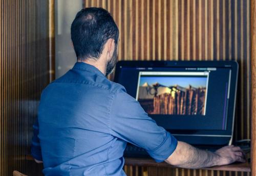 a man sitting in front of a laptop computer at Mercure Port La Grande Motte in La Grande-Motte