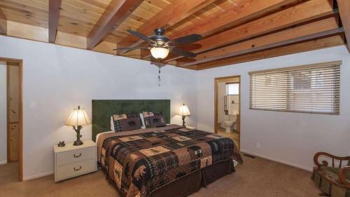 een slaapkamer met een bed en een plafondventilator bij Lakefront Dock Hot Tub Swingset Deck Views Classic Lake House by AvantStay in Big Bear Lake
