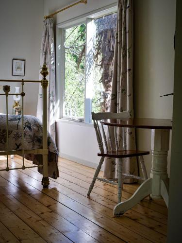 a bedroom with a bed and a chair and a window at Birdsland Suite in Belgrave Heights