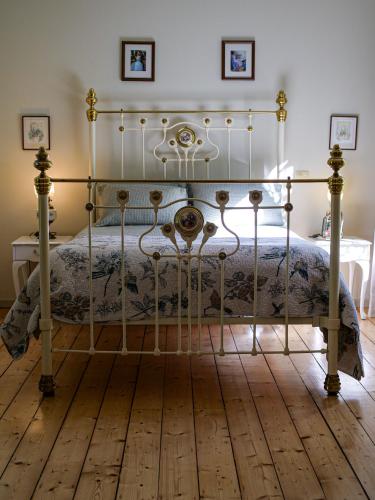 an ornate bed in a bedroom with a wooden floor at Birdsland Suite in Belgrave Heights
