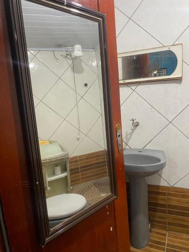 a bathroom with a toilet and a sink at Kitnet perto da praia Coroados in Guaratuba