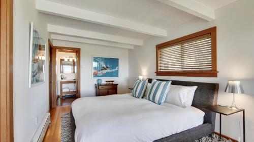 a bedroom with a large white bed and a window at Modern Love by AvantStay Serene Home in Arch Cape w Large Yard in Great Location in Arch Cape