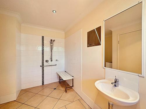 Un baño blanco con lavabo y ducha. en Neat 1BR - AC & Parking, en Moranbah