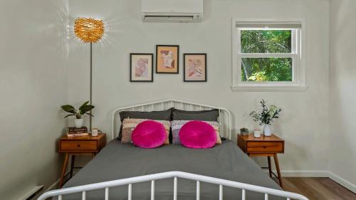 Lake It Right by AvantStay Lakefront w Dock Hot Tub Fire Pit Game Room في Long Pond: غرفة نوم مع سرير مع وسادتين ورديتين