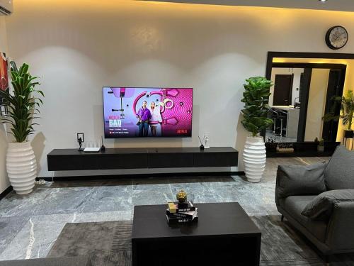 een woonkamer met een flatscreen-tv aan de muur bij bedandchuckle in Kaduna