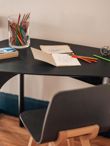 a black desk with a chair and a glass of pens at Maison Resaurie - Hôtel in Biarritz