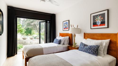 two beds in a room with a window at Marquee By AvantStay Modern Stylish Estate w Pool Entertainers Courtyard in Boyes Hot Springs