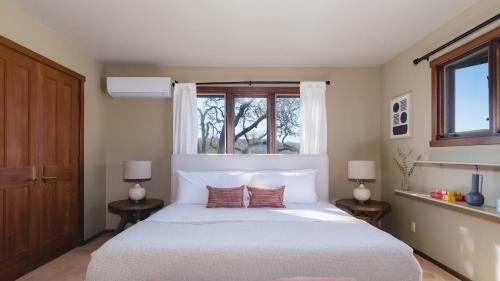 a bedroom with a large white bed with two lamps at Gable by AvantStay Beautiful 3.5 Acre Oasis w Gorgeous Views Pool Hot Tub in Santa Rosa