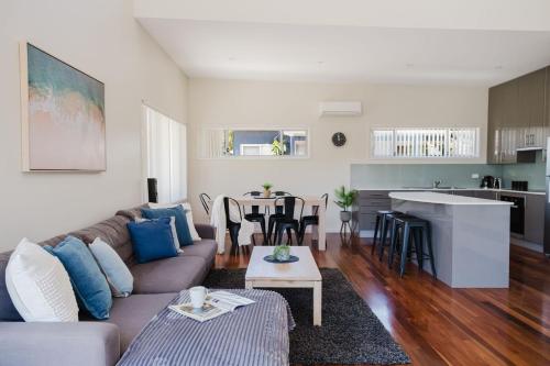 a living room with a couch and a table at Ocean Stays - Mollymook in Mollymook