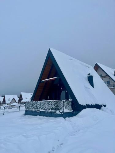 a building covered in snow with snow on the roof at Villa Merima Vlasic in Vlasic