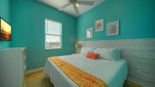 a bedroom with a bed with blue walls at Ocean Devotion by AvantStay in Port Aransas