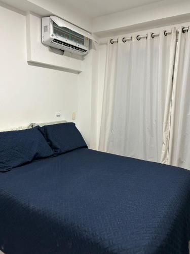 a bedroom with a blue bed and a air conditioner at In mare Bali Resort in Parnamirim