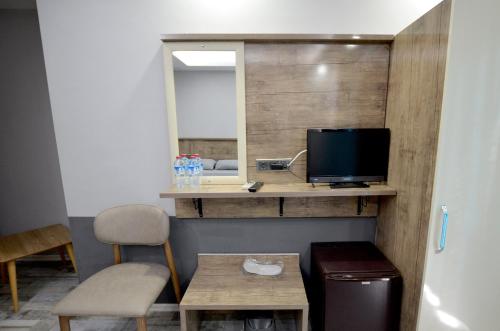 Zimmer mit einem Schreibtisch, einem TV und einem Tisch. in der Unterkunft Tüm Palace Otel in Bandırma