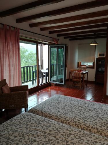 a bedroom with a bed and a balcony with a table at T0 Eira Frente in Vieira do Minho