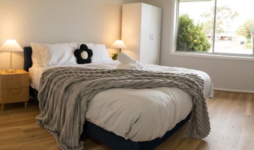 a bedroom with a large bed with a blanket on it at Hobart Family Retreat with Spa and Backyard Near Airport in Sorell