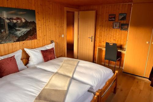 a bedroom with a white bed with a picture on the wall at Chalet Alpenheim 2 OG in Bettmeralp