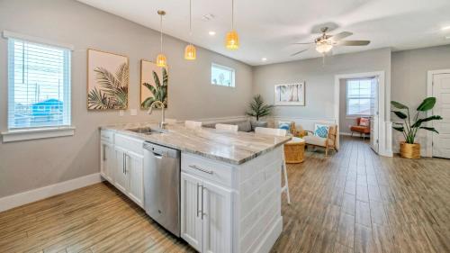 Una cocina con encimera y una sala de estar. en Saltwater Pool Rooftop Deck w View Near Beach The Blue Crab by AvantStay, en Port Aransas