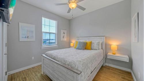 Una habitación blanca con una cama y una ventana en Saltwater Pool Rooftop Deck w View Near Beach The Blue Crab by AvantStay, en Port Aransas