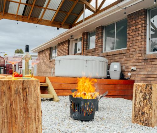 a fire pit in a yard in front of a house at Hobart Family Retreat with Spa and Backyard Near Airport in Sorell