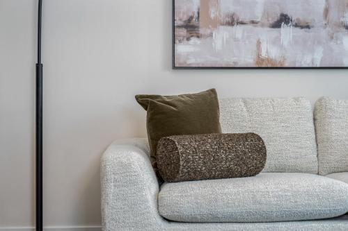 a couch with a pillow sitting in a living room at Hyatus Luxury Residences Boston Assembly Row in Somerville