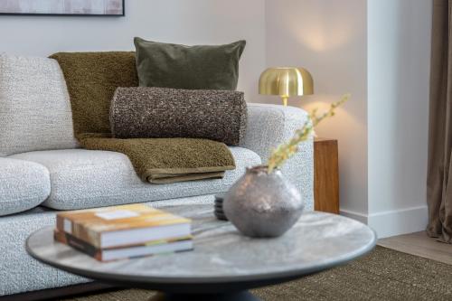 a living room with a couch and a table with books at Hyatus Luxury Residences Boston Assembly Row in Somerville