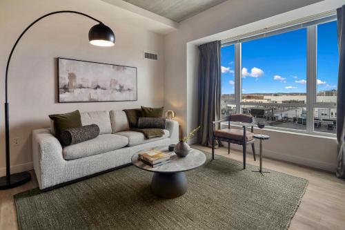 a living room with a couch and a table at Hyatus Luxury Residences Boston Assembly Row in Somerville