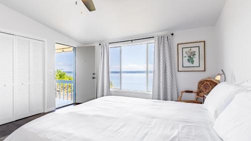 a bedroom with a large white bed and a window at Saratoga by the Sea by AvantStay Panoramic View Near Langley in Langley