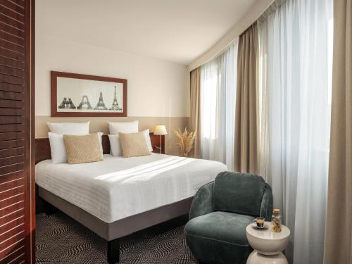 una habitación de hotel con una cama y una silla en Mercure Paris Gare Montparnasse TGV, en París