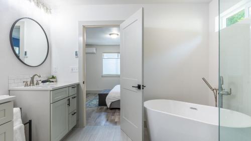 a white bathroom with a tub and a sink at Twin Oaks Retreat by AvantStay Mins to Freeland in Langley