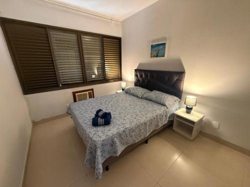 a bedroom with a bed with a black head board at Residencial Ponta das Canas in Florianópolis