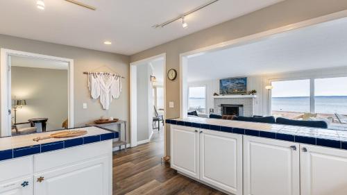 a kitchen with white cabinets and blue counter tops at Harrington Hideaway by AvantStay Beach Access in Coupeville