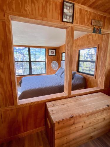 a bedroom in a log cabin with a bed and a mirror at On the Rocks! in Concan
