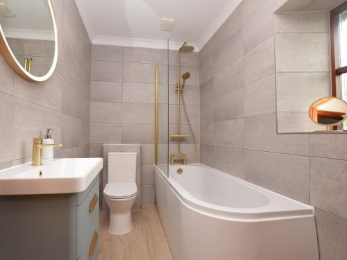 a bathroom with a tub and a toilet and a sink at 2 Bed in Clynderwen 82445 in Clynderwen