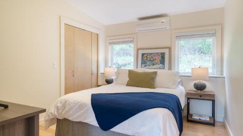 a bedroom with a bed with a blue blanket on it at Secluded Modern Enclosed Patio Forest Views Woodland Zen by AvantStay in Stockbridge