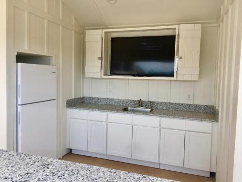 a kitchen with a sink and a white refrigerator at Pretty Penny in Concan
