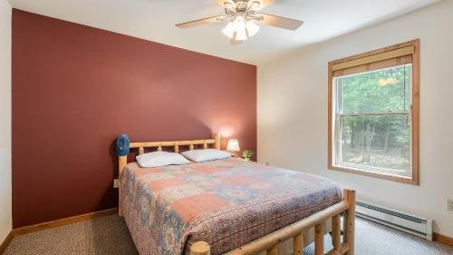 Un dormitorio con una cama y un ventilador de techo. en Coyote Cabin by AvantStay Hot Tub Walk to Lake, en Lake Harmony