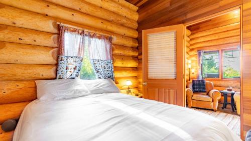 Penn Cove Overlook by AvantStay Cabin w Views في أوك هاربور: غرفة نوم مع سرير في كوخ خشبي