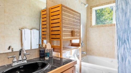 Harborview Getaway by AvantStay Walk to Beach في لانغلي: حمام مع مغسلة وحوض استحمام